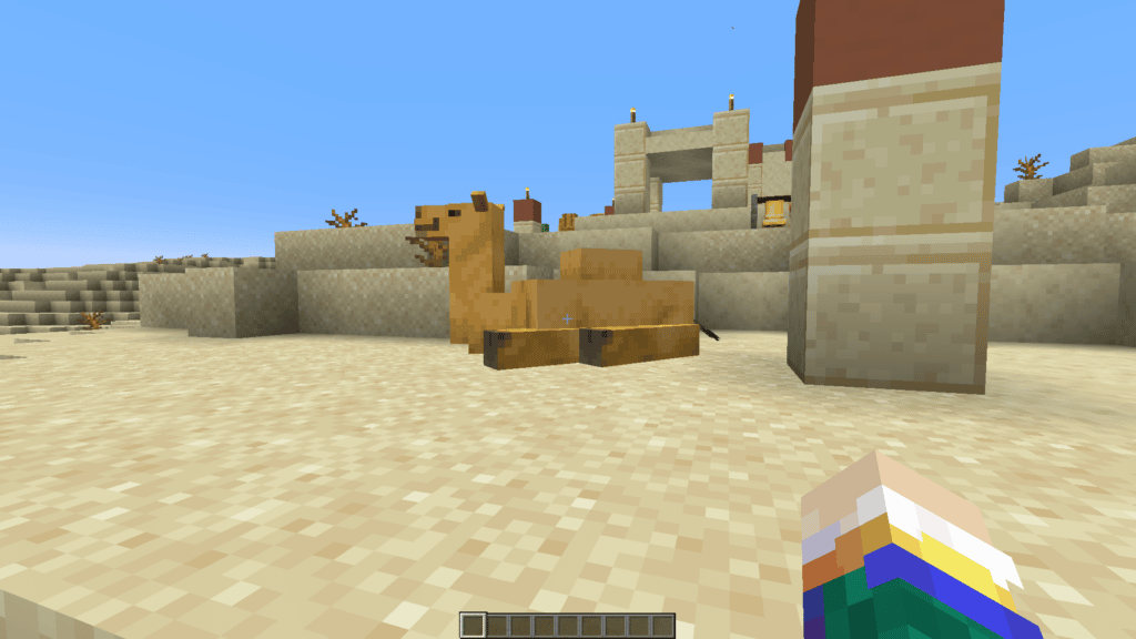 A camel in Minecraft 1.20 sitting down in a desert village.
