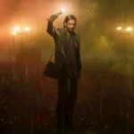 Image shows Alan Wake standing in rain