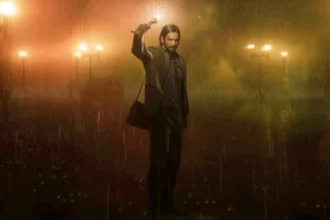 Image shows Alan Wake standing in rain