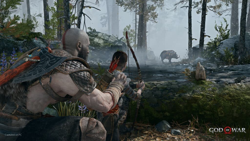 Kratos teaching his son Atreus how to use the bow to hunt a boar in God of War
