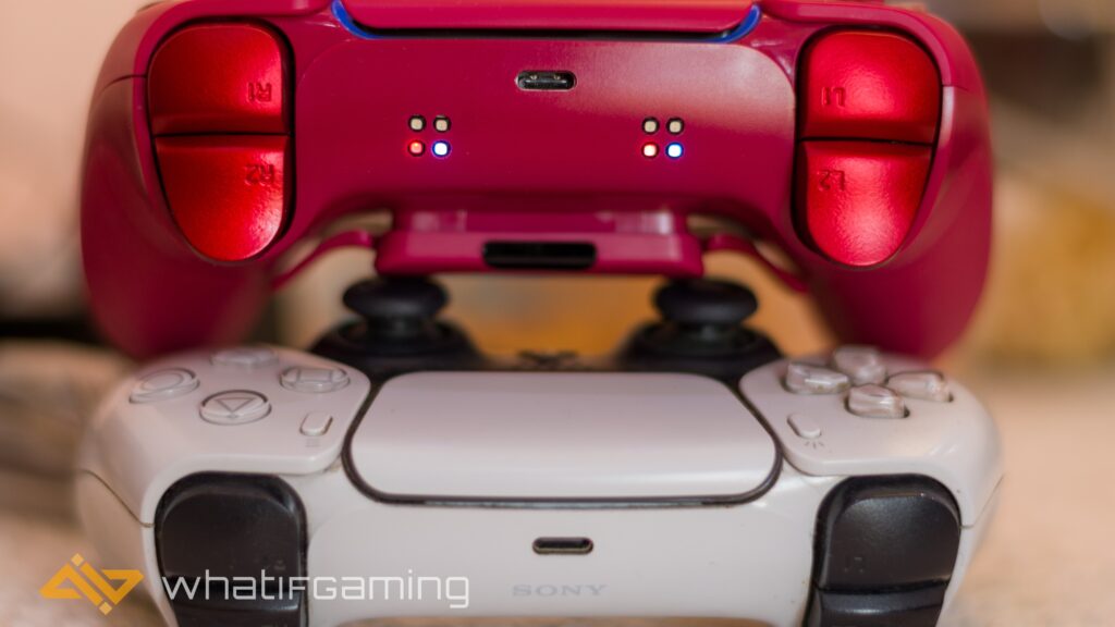 Image shows a red controller on top of a white PS5 controller