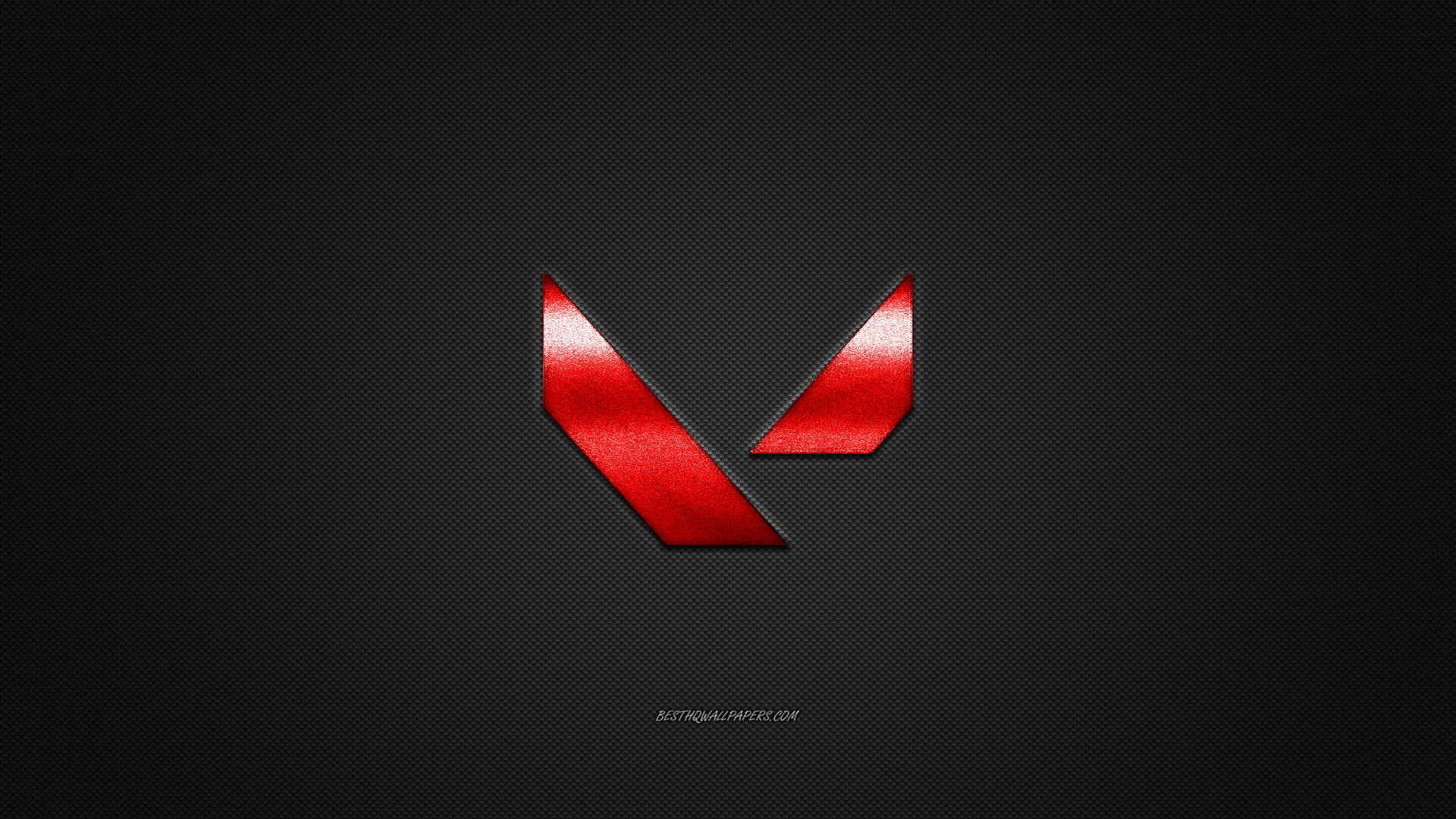 Image by N/A – The Valorant logo over a carbon fiber background.