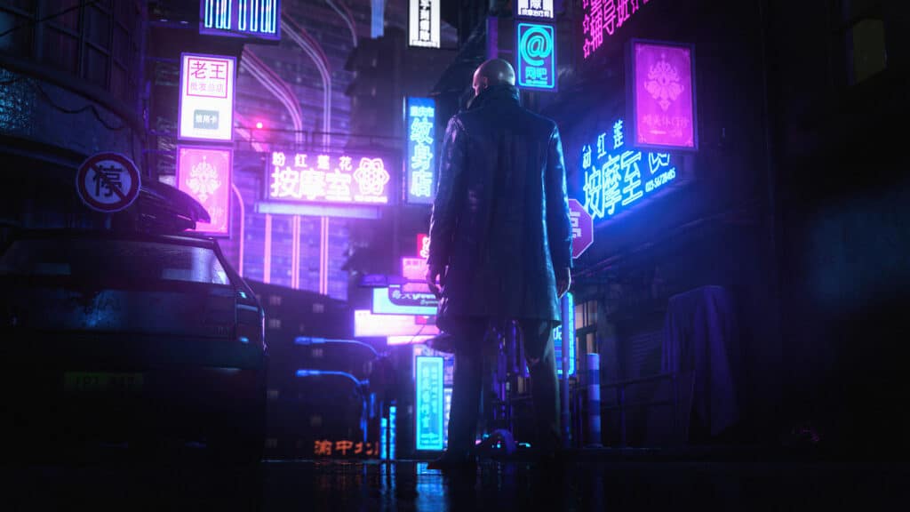 agent 47 standing in front of a neon lit part of a city