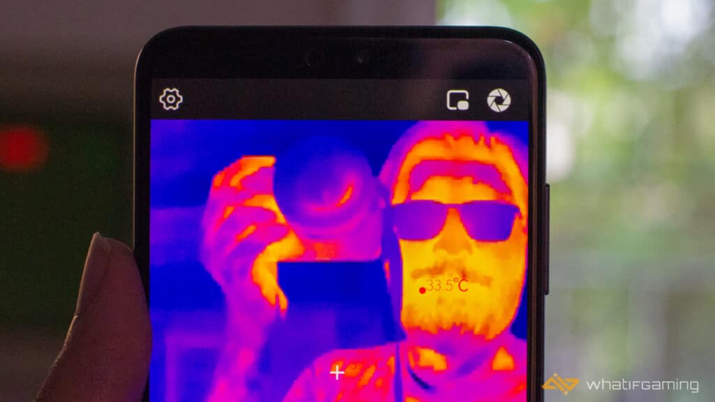 Image has a person taking a thermal selfie